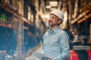 Smiling man with hard hat in a warehouse